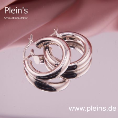 Ein Paar hochglanzpolierte, markante Klappcreolen aus 925 Sterling Silber mit 20 mm Durchmesser auf einer Spiegelfläche liegend.